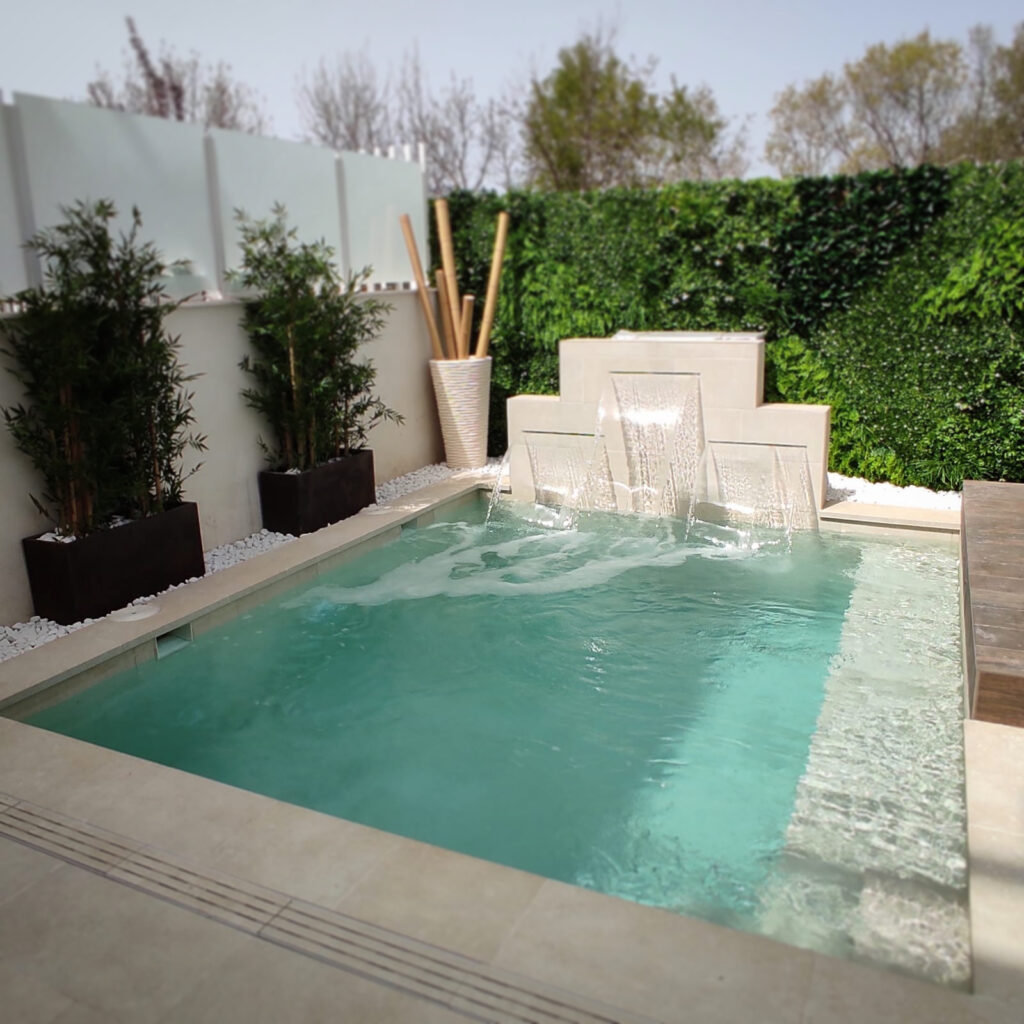 zona de relax en terraza con piscina que incluye tres cascadas en su interior