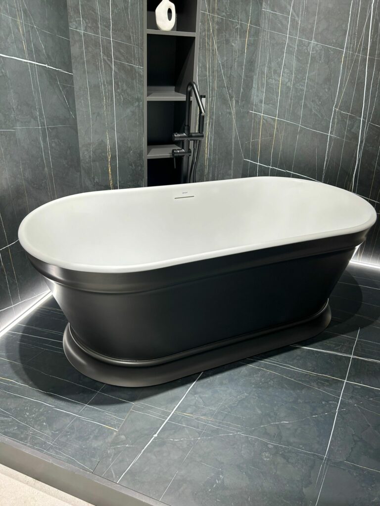 Bañera exenta a suelo de elegante corte clásico, líneas redondeadas y color oscuro en su exterior