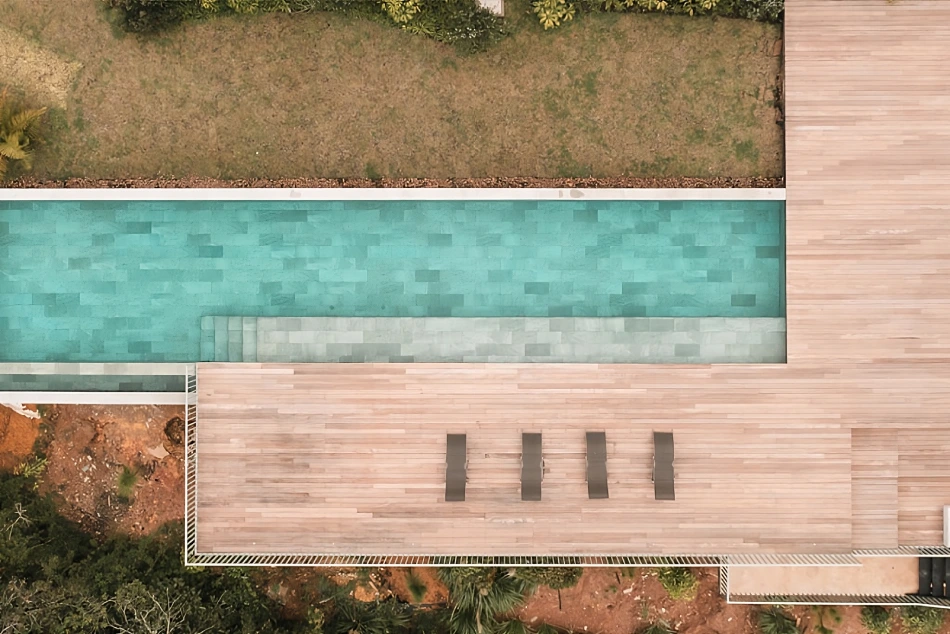 impresionante piscina con baldosa porcelánica combinada en exterior e interior