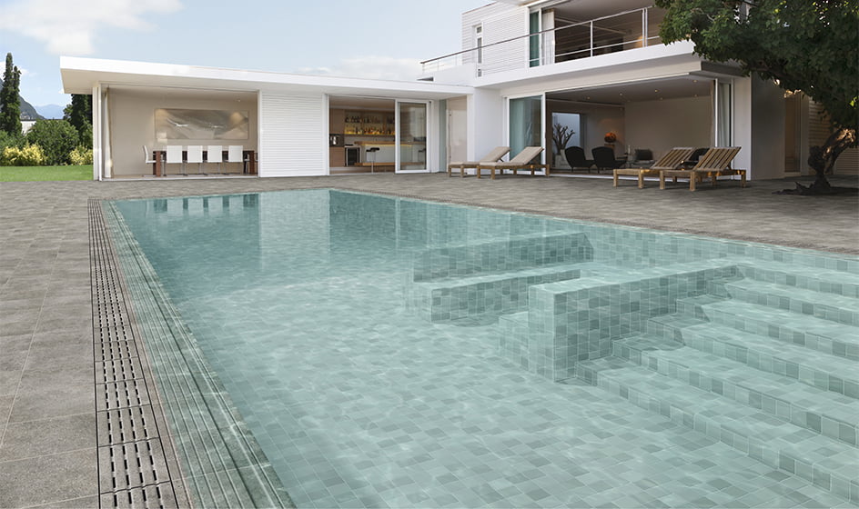 Escalera de obra en piscina de color turquesa y sistema desbordante