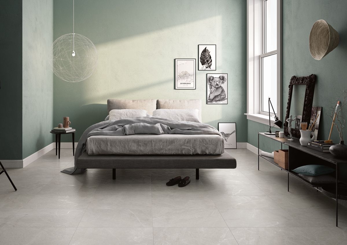 Dormitorio con pared en tono verde combinada con suelo porcelánico imitación piedra