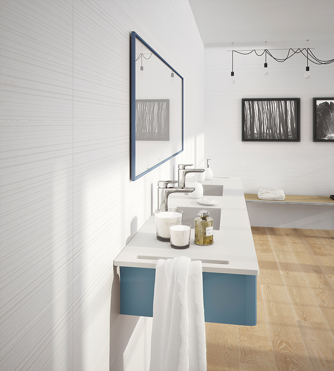 Pared en cuarto de baño revestida con piezas cerámicas con relieve y suelo de madera porcelánica