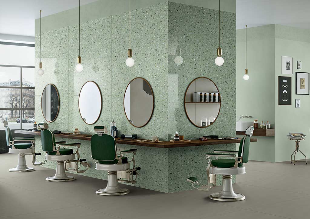 Peluquería con pared a base de terrazo con el fondo verde y suelo porcelánico cementoso